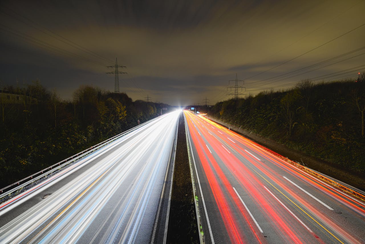 Captivating long exposure photo showcasing dynamic light trails on a nighttime highway.